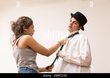 Ragazza bussa la cravatta del ragazzo che si prepara per il lavoro da casa. È senza ascolto Foto Stock