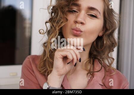 Foto closeup di bella divertente abbastanza curly signora positivo buon umore invio aria baci Foto Stock