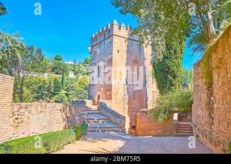 Passeggia nel verde ombroso giardino dell'Alhambra e goditi la vista sulla Torre de los Picos (Torre dei punti) con finestre ad arco in stile arabo e battaglie Foto Stock