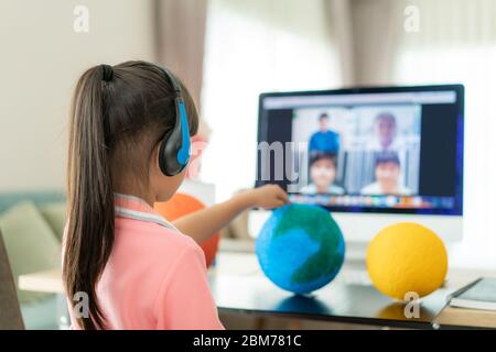 Video conferenza di apprendimento live per studenti asiatici con insegnante e altri compagni di classe che danno una presentazione, mostrando un modello solare progetto, Homeschooling an Foto Stock