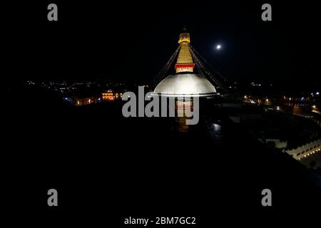 Kathmandu, Nepal. 7 maggio 2020. Light illumina la Boudhanath Stupa, riflessa su una pozza da una luna piena durante Buddha Jayanti, l'anniversario di nascita di Buddha a Kathmandu, Nepal, Giovedi, 7 maggio 2020. Credit: Skanda Gautam/ZUMA Wire/Alamy Live News Foto Stock