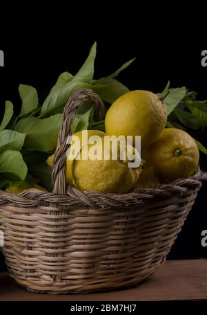 limoni organici maturi su canestro di canna Foto Stock