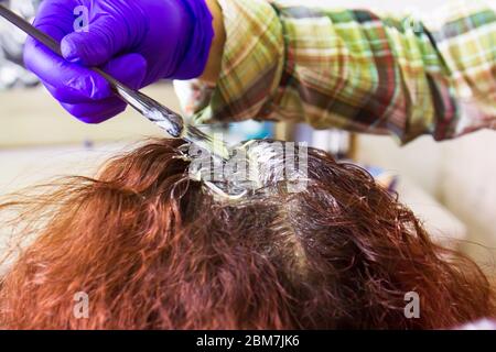 Il parrucchiere tinge i capelli del cliente in salone di bellezza Foto Stock