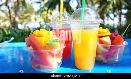 Agrumi e fette di frutta esotica su un tavolo di legno blu - estate Foto Stock