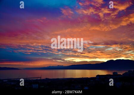 Bellissimo cielo dorato e tramonto sopra la montagna Učka e il mare Adriatico a Fiume, Croazia Foto Stock