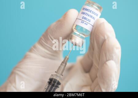 Medico che usa una siringa per ottenere il vaccino di remdesivir per Covid-19 o coronavirus dal flacone - concetto di vaccinazione con Covid-19, ricerca, influenza pandemica Foto Stock