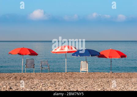 Ombrelloni e sedie che si affacciano sull'orizzonte mediterraneo del mare sulla spiaggia vuota di la Herradura, Costa Tropical, Andalusia, Spagna Foto Stock