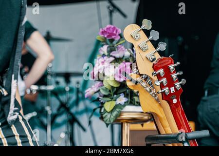 Chitarra con fiori sul palco Foto Stock