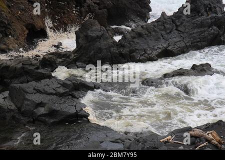 Il torrente Palikea attraversa la roccia vulcanica e scorre nell'Oceano Pacifico presso l'Oheo Gulch a Hana, Maui, Hawaii, USA Foto Stock