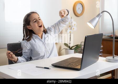 Ragazza che urla di fronte al computer a casa Foto Stock