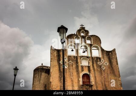 Chiesa coloniale in Messico sul giorno di tempesta. Le campane sono incrinati e si stagliano contro un cielo tempestoso. Foto Stock