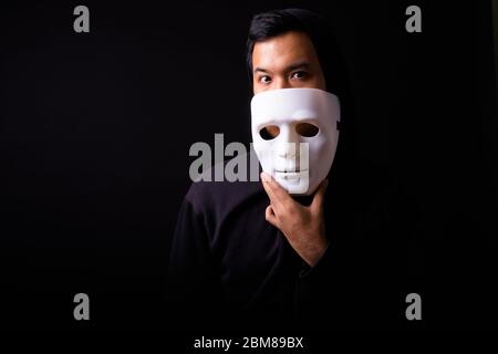 Ritratto di giovane asiatico con maschera con cappuccio Foto Stock