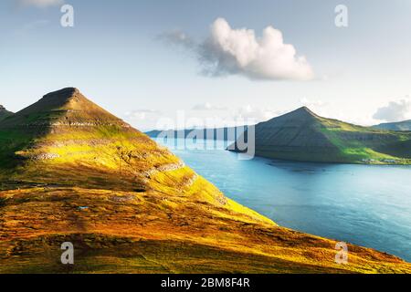 Vista incredibile delle isole Faerøer, incandescente dalla luce del tramonto. Fotografia di paesaggi Foto Stock