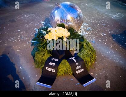 07 maggio 2020, Amburgo: Una corona funeraria si trova accanto a una palla da discoteca scoppiata a una protesta di restauratori di quartiere, club e proprietari di pub su Beatles Platz di fronte al Große Freiheit sulla Reeperbahn. Nel quartiere di culto di Amburgo, St. Pauli, i proprietari di bar e pub hanno attirato l'attenzione sulle loro esigenze esistenziali il giovedì sera a causa della crisi Corona e hanno chiesto più aiuti finanziari. L'iniziatore dell'azione di protesta sulla Reeperbahn era Dragqueen O. Jones, che gestisce diversi bar nel quartiere stesso. (Al dpa "barre di rieperbahn in difficoltà - "assenza di luce alla fine del tunnel") Foto Stock