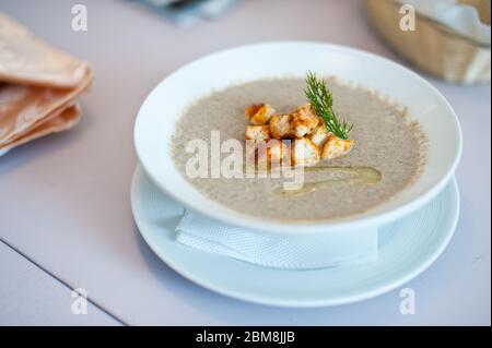 Zuppa di crema con funghi champignon e patate in ciotola bianca. Profondità di campo bassa. Foto Stock