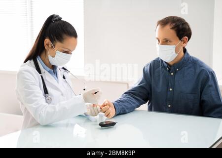 Medico in maschera facciale controllo del livello di zucchero nel sangue Foto Stock