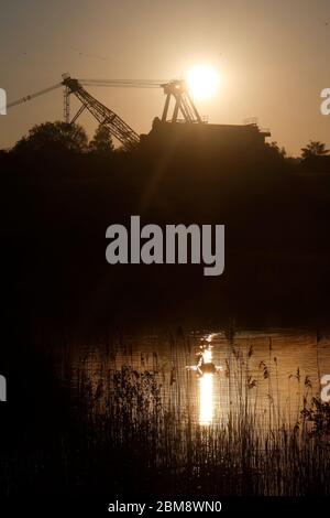 Alba dietro un dragline a piedi conservato a RSPB St Aidan's a Swillington, Leeds, Regno Unito Foto Stock