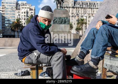 Montevideo, Montevideo, Uruguay. 7 maggio 2020. 20200507- UN cliente ottiene le sue scarpe lucidate a Plaza Independencia a Montevideo, Uruguay. Il Presidente Lacalle Pou ha chiesto la riapertura di alcune industrie e ha incoraggiato la gente ad adottare misure preventive contro il COVID-19 per tornare alla normalità. Credit: Mauricio Zina/ZUMA Wire/Alamy Live News Foto Stock