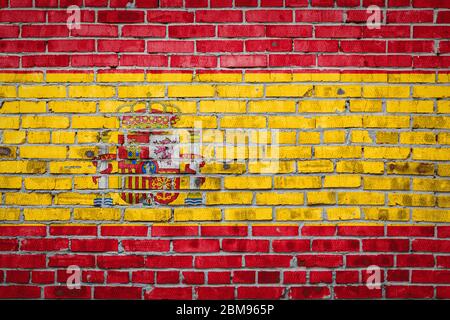 Bandiera nazionale della Spagna raffigurante in colori di vernice su un vecchio muro di mattoni. Bandiera banner su sfondo muro di mattoni. Foto Stock