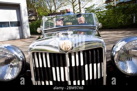 Amburgo, Germania. 06 maggio 2020. Claus Mirbach e sua moglie Britta sono seduti nella loro auto classica 'MG - Model TC', costruita nel 1947, su un parcheggio di fronte alla loro agenzia auto classica. Il numero di vetture classiche registrate in Germania è nuovamente aumentato. Alla data di scadenza del 1° gennaio 2020, 13 078 veicoli di almeno 30 anni - compresi motocicli, automobili, camion, autobus e trattori - sono stati immatricolati solo ad Amburgo, secondo i dati forniti dalla Federal Motor Transport Authority (KBA). Credit: Christian Charisius/dpa/Alamy Live News Foto Stock