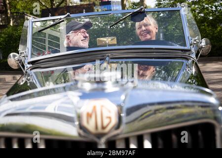 Amburgo, Germania. 06 maggio 2020. Claus Mirbach e sua moglie Britta sono seduti nella loro auto classica 'MG - Model TC', costruita nel 1947, su un parcheggio di fronte alla loro agenzia auto classica. Il numero di vetture classiche registrate in Germania è nuovamente aumentato. Alla data di scadenza del 1° gennaio 2020, 13 078 veicoli di almeno 30 anni - compresi motocicli, automobili, camion, autobus e trattori - sono stati immatricolati solo ad Amburgo, secondo i dati forniti dalla Federal Motor Transport Authority (KBA). Credit: Christian Charisius/dpa/Alamy Live News Foto Stock