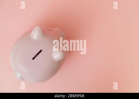 Primo piano vista dall'alto del piggy bank su sfondo rosa. Concetto di risparmio di denaro per il tempo della disoccupazione e della crisi. Luogo per la pubblicità. Foto Stock