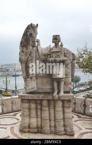 Budapest, Ungheria - 6 novembre 2019: Szent Istvan Kiraly, statua di Santo Stefano sulla collina di Gellert. La città lungo il fiume Danubio sullo sfondo. Scultura. Foto verticale. Foto Stock