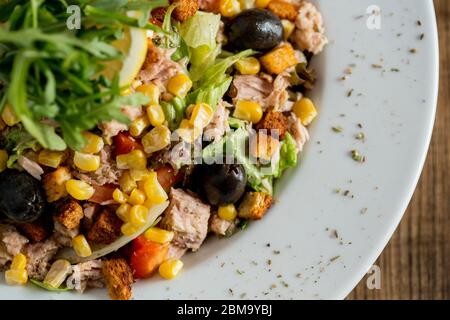 Insalata di Tun con olive, mais e razzo sul tavolo Foto Stock