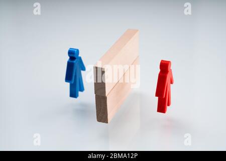 Rosso e Blue Pawn separati da blocchi di legno Foto Stock