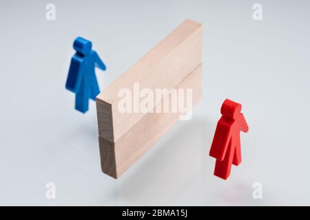 Rosso e Blue Pawn separati da blocchi di legno Foto Stock