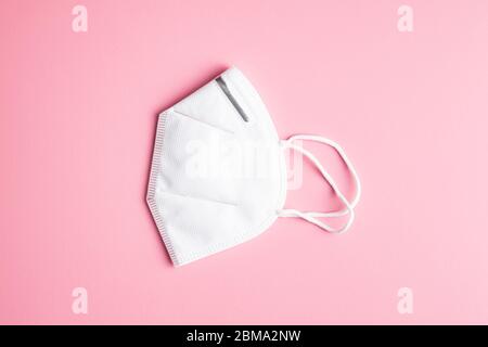 Maschera di protezione Kn95. Respiratore bianco su sfondo rosa. Foto Stock