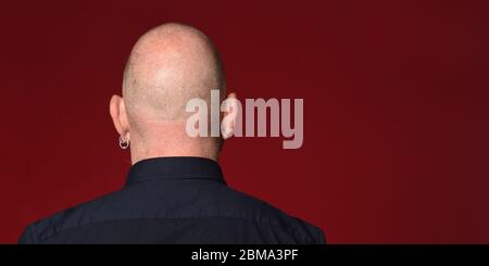 ritratto di un uomo calvo vista posteriore su sfondo rosso Foto Stock