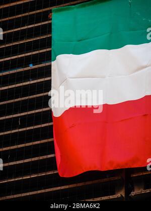 Cremona, Lombardia, Italia - 5 6 7 2020 Maggio - bandiera italiana su una finestra Città deserta durante il blocco dell'epidemia di coronavirus fase 2 Foto Stock