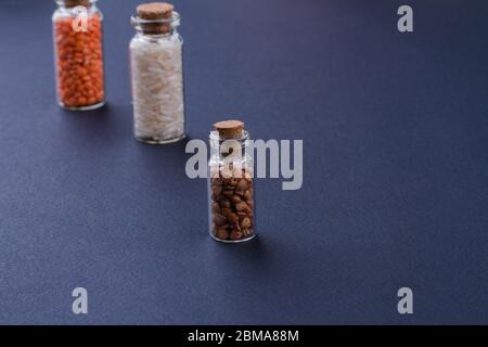 Contenitori in vetro con tappi in sughero riempiti di grani. Foto Stock