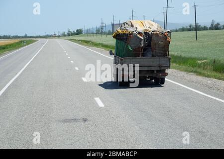 Il carrello trasporta tutto il materiale. Cigan camion uomo povero Foto Stock