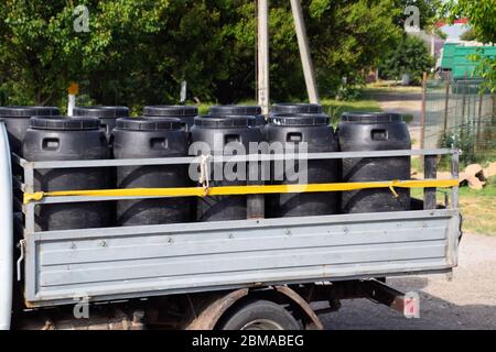Trasporto di agenti chimici in fusti di plastica su un camion. Foto Stock