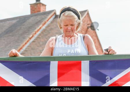 Hunnington, Worcestershire, Regno Unito. 8 maggio 2020. Mentre il Regno Unito celebra il 75° anniversario della Giornata del Ve, una signora inchina la testa per il minuto silenzio in onore nel villaggio di Hunnington, Worcestershire. Credit: Peter Lopeman/Alamy Live News Foto Stock