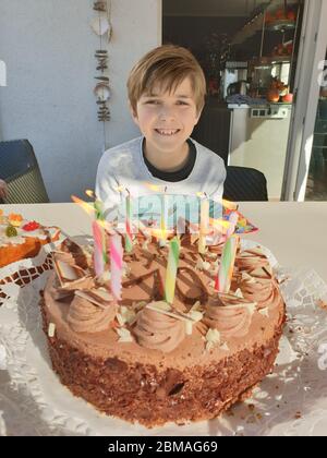 Compleanno ragazzo con torta di compleanno e candele bruciate per il suo decimo compleanno, Germania Foto Stock
