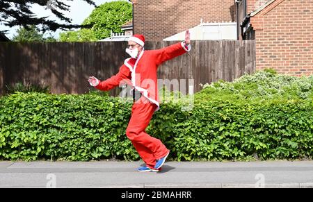 Littlehampton UK 8 maggio 2020 - un runner vestito da Babbo Natale che prende il suo esercizio di lock down a Rustington vicino Littlehampton durante le restrizioni di lock down del coronavirus COVID-19 pandemic. : Credit Simon Dack / Alamy Live News Foto Stock