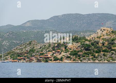 Kalekoy villaggio con case in pietra e castello sulla cima della collina nella baia di Uchagiz in Turchia vicino città sommersa di Kekova Foto Stock