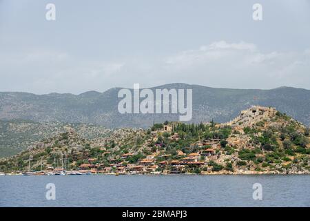 Kalekoy villaggio con case in pietra e castello sulla cima della collina nella baia di Uchagiz in Turchia vicino città sommersa di Kekova Foto Stock