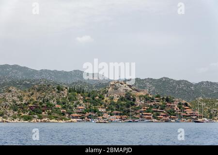 Kalekoy villaggio con case in pietra e castello sulla cima della collina nella baia di Uchagiz in Turchia vicino città sommersa di Kekova Foto Stock