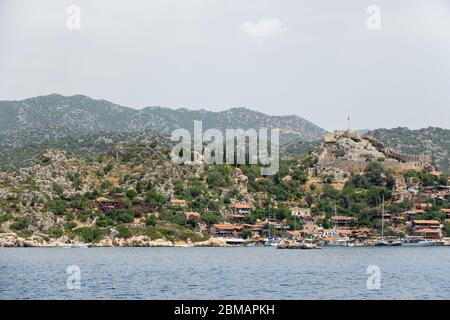 Kalekoy villaggio con case in pietra e castello sulla cima della collina nella baia di Uchagiz in Turchia vicino città sommersa di Kekova Foto Stock