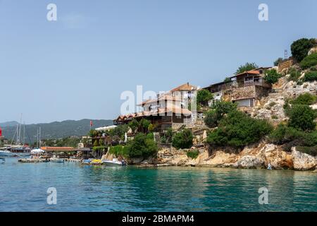 Kalekoy, Simena , Turchia - 03 giugno 2019: Kalekoy villaggio con case in pietra e castello sulla cima della collina nella baia di Uchagiz in Turchia vicino città sommersa Foto Stock