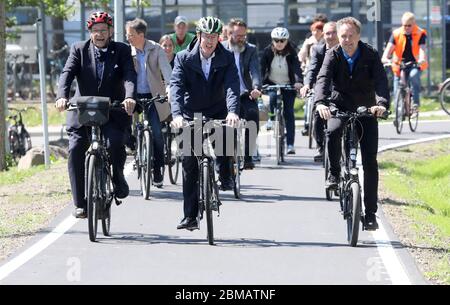 Rostock, Germania. 8 maggio 2020. Dopo l'apertura della prima superstrada ciclabile della città anseatica, Wolfgang Schareck (fronte) (l-r), il Rettore dell'Università, Christian Pegel (SPD), il Ministro delle infrastrutture e Holger Matthäus (Verdi), Senatore delle infrastrutture a Rostock, percorreranno la nuova rotta del campus universitario Albert-Einstein-Strasse con una scorta. La sezione attualmente lunga 1,000 metri è completamente priva di traffico automobilistico. Credit: Bernd Wüstneck/dpa-Zentralbild/dpa/Alamy Live News Foto Stock