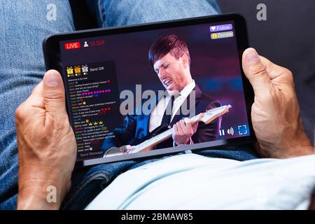 Streaming di video musicali in diretta con la suoneria sul Tablet computer Foto Stock