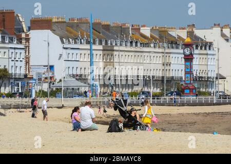 Weymouth, Dorset, Regno Unito. 8 maggio 2020. UK Weather: Una famiglia sulla spiaggia in una giornata di sole caldo presso la località balneare di Weymouth a Dorset, il 75 ° anniversario di VE Day durante il blocco dei coronavirus. Credito immagine: Graham Hunt/Alamy Live News Foto Stock