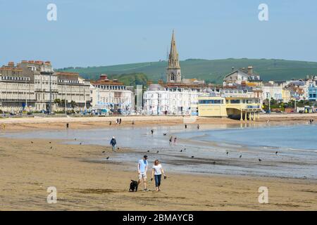 Weymouth, Dorset, Regno Unito. 8 maggio 2020. UK Weather: Persone che si esercitano sulla spiaggia in una giornata di sole caldo presso la località balneare di Weymouth a Dorset nel 75 ° anniversario di VE Day durante il blocco coronavirus. Credito immagine: Graham Hunt/Alamy Live News Foto Stock