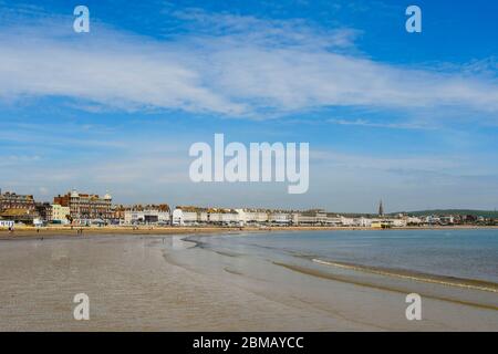 Weymouth, Dorset, Regno Unito. 8 maggio 2020. UK Weather: Una vista della spiaggia e del lungomare in una giornata di sole caldo presso la località balneare di Weymouth a Dorset, il 75 ° anniversario di VE Day durante il blocco dei coronavirus. Credito immagine: Graham Hunt/Alamy Live News Foto Stock