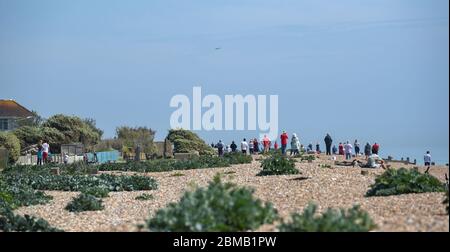 Littlehampton UK 8 maggio 2020 - la gente si raduna sulla spiaggia a Ferring vicino Worthing per guardare il fuoco volare passato in lontananza per commemorare l'anniversario del VE Day durante le restrizioni di blocco del coronavirus COVID-19 pandemic. E '75 anni da quando la vittoria in Europa sui tedeschi è stata annunciata durante la seconda guerra mondiale: Credit Simon Dack / Alamy Live News Foto Stock